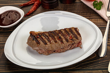 Grilled beef striploin steak with sauce