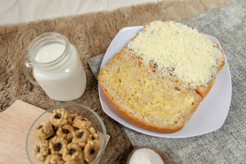 Bread with cheese, sweetened condensed milk, and butter. With white milk and snack on a table for breakfast