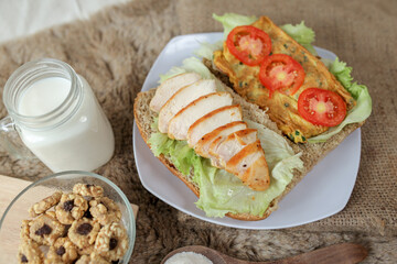 Big breakfast, bread, chicken slice, tomato, lettuce, smoked beef, egg, salad with milk. Bread sandwich fresh and healthy food meal lunch dinner breakfast slices of sandwiches.