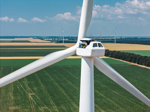 Engineer repairing wind turbine generator from inside the nacelle - Powered by Adobe