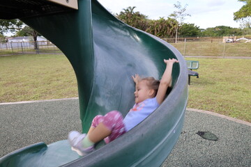 Little girl on the slide on playground