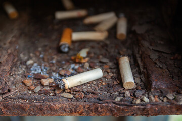 Close up of cigarette butts carelessly thrown away. Although considered harmful to health,...