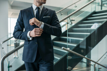 Elegant Businessman in a Dark Suit on Stairs Indoors