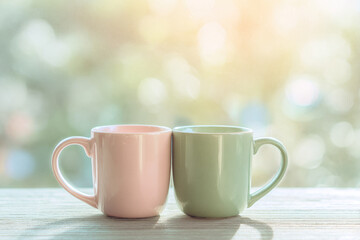 Fototapeta premium Pastel coffee mug soft focus two ceramic cups touching sunlight bokeh background morning romantic gentle cozy friendship