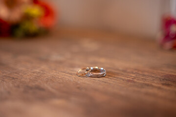 Les anneaux de mariage avec le bouquet de la mari&eacute;e sur une table en bois