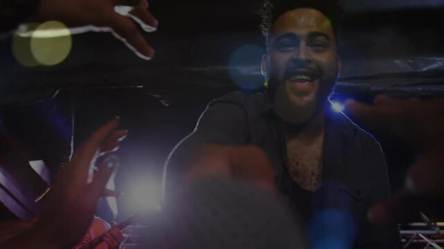 Singer extending microphone to crowd under concert lights while audience reaching for interaction