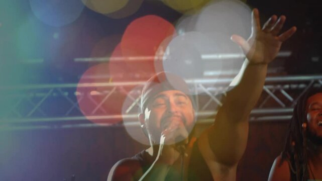 Focus shifting sending singer stepping forward gripping mic and belting with bokeh for music crowd
