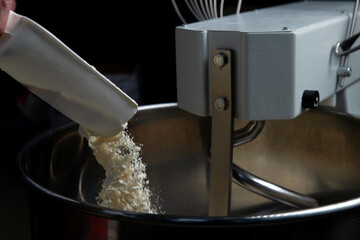 Pouring flour into a dough mixer.
