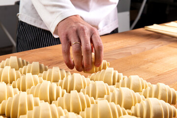 Pastry chef lays out raw croissants.