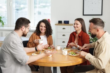 Colleagues chatting during lunch break in office