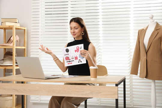 Professional stylist having online consultation with client via laptop at desk indoors - Powered by Adobe
