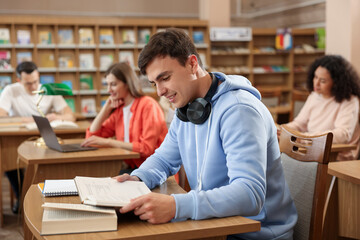People studying at desks in public library, selective focus