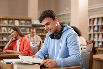 People studying at desks in public library, selective focus