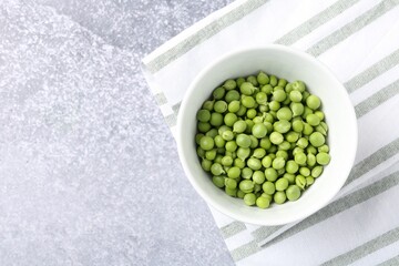 Fresh ripe green peas on grey table, top view. Space for text