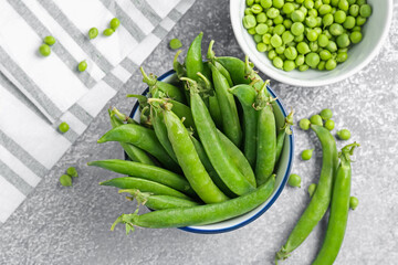 Fresh ripe green peas on grey table, flat lay