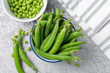 Fresh ripe green peas on grey table, flat lay