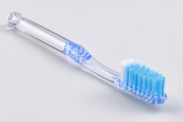 toothbrush with transparent handle and soft blue color on white background