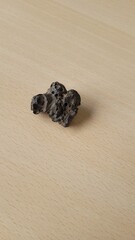 pierre étrange similaire à une météorite sur table en bois