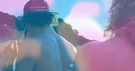 Friends swaying to music, raising red cups beachside for travel marketing, lens flares drifting