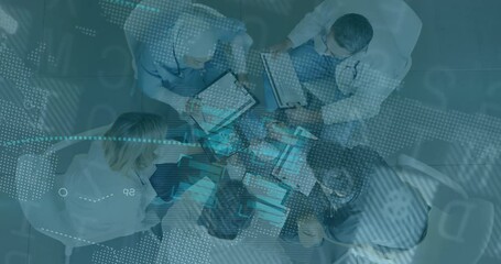 Woman tapping tablet at business meeting and five coworkers uniting hands under fading overlay - Powered by Adobe