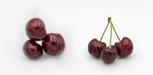 Fresh ripe dark red cherries with stalks, on white background