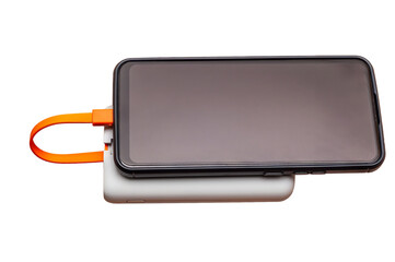 A smartphone on a power bank, connected by an orange cable against a white backdrop.