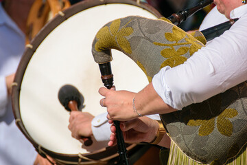 hands playing galician bagpipes with a drum in background, galicia cultural heritage expressed...