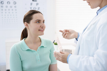 Obraz premium Ophthalmologist giving contact lenses to patient in office, closeup