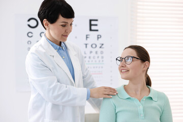 Ophthalmologist examining patient's vision with glasses in clinic