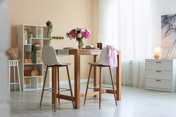 Beautiful table setting with bouquet of peonies in dining room. Interior design