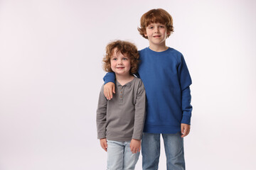 Cute little brothers posing on white background. Space for text