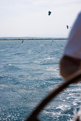Sailing in Rosas, Costa Brava, watching kitesurfing athletes riding waves