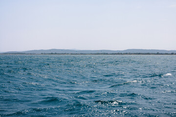 Kitesurfing in Rosas, Costa Brava, with choppy sea and beach in the background