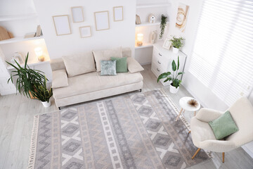 Comfortable sofa and stylish rug in room, above view. Interior design
