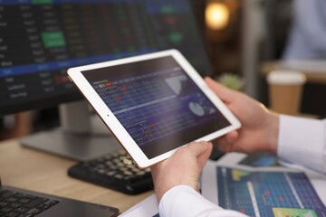Stock exchange. Man working at desk in office, closeup