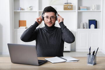 Man learning online using laptop at desk indoors. Self-study