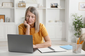 Woman learning online using laptop at table indoors. Self-study