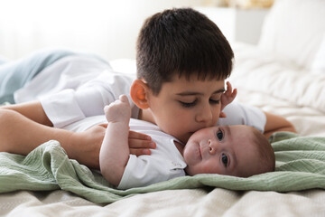 Cute little brothers on bed at home