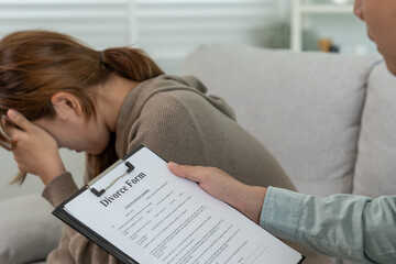 Divorce. Husband review and show sign Divorce form. Couples desperate and disappointed after marriage. wife sad, upset and frustrated after quarrels conflict. distrust, love problems
