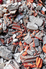 Pile of broken red and gray bricks and concrete rubble