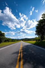 Naklejka premium Scenic open road under bright blue sky with fluffy white clouds in countryside