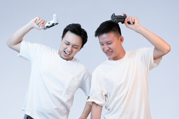 two young asian man showing frustrated in losing games , studio background