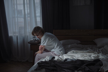 Sadness loneliness and mental health challenges consume young woman sitting on bed
