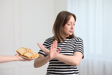 Gluten free diet. Woman refusing from bread indoors