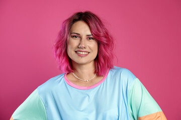 Fototapeta premium Beautiful woman with bright dyed hair on pink background