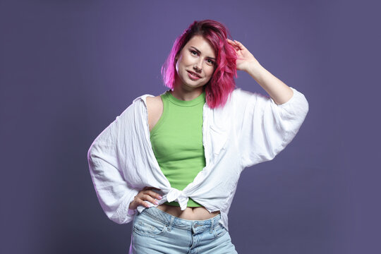 Fototapeta Beautiful woman with pink dyed hair on violet background
