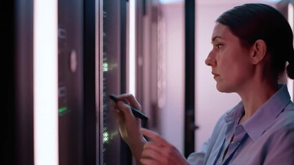 Professional woman managing data servers in a modern high tech facility