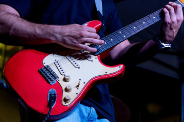 Man playing electric guitar during a live concert on a summer music festival