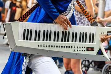 Latin artist playing keytar during a summer music festival performance