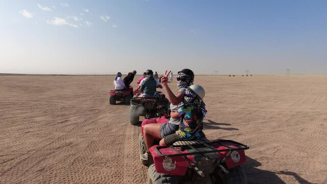 Woman and child show off their skills on a quad bike in the Egyptian desert